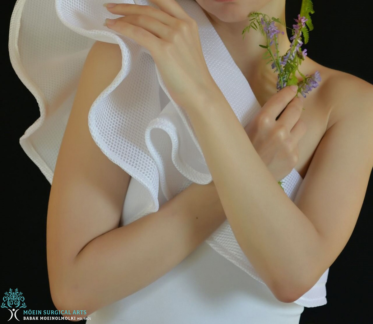 A woman in a white dress holding a flower.