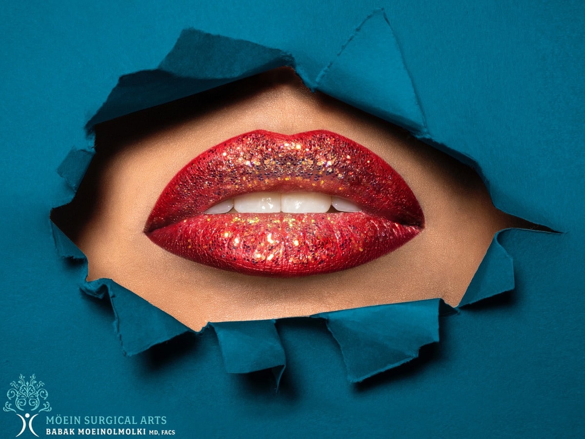 A woman's lips are shown through a hole in a blue paper.