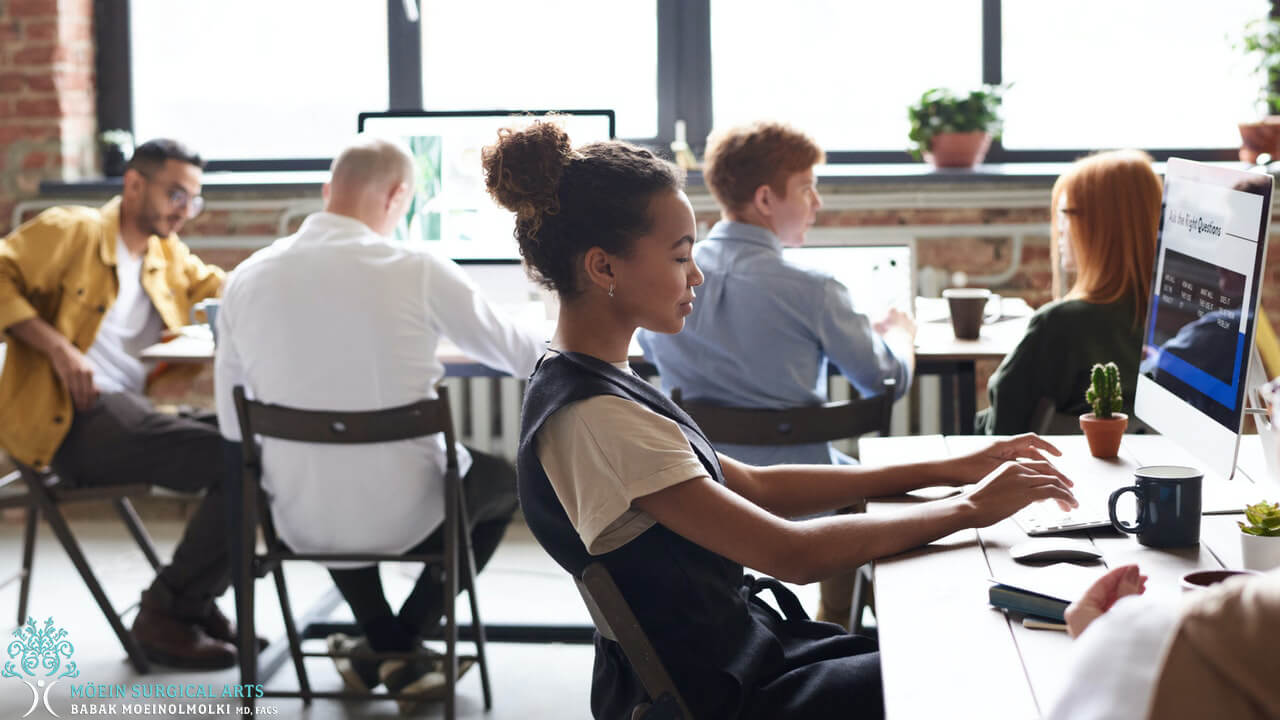 A group of people working on computers in an office.