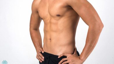 A man is posing in front of a white background.