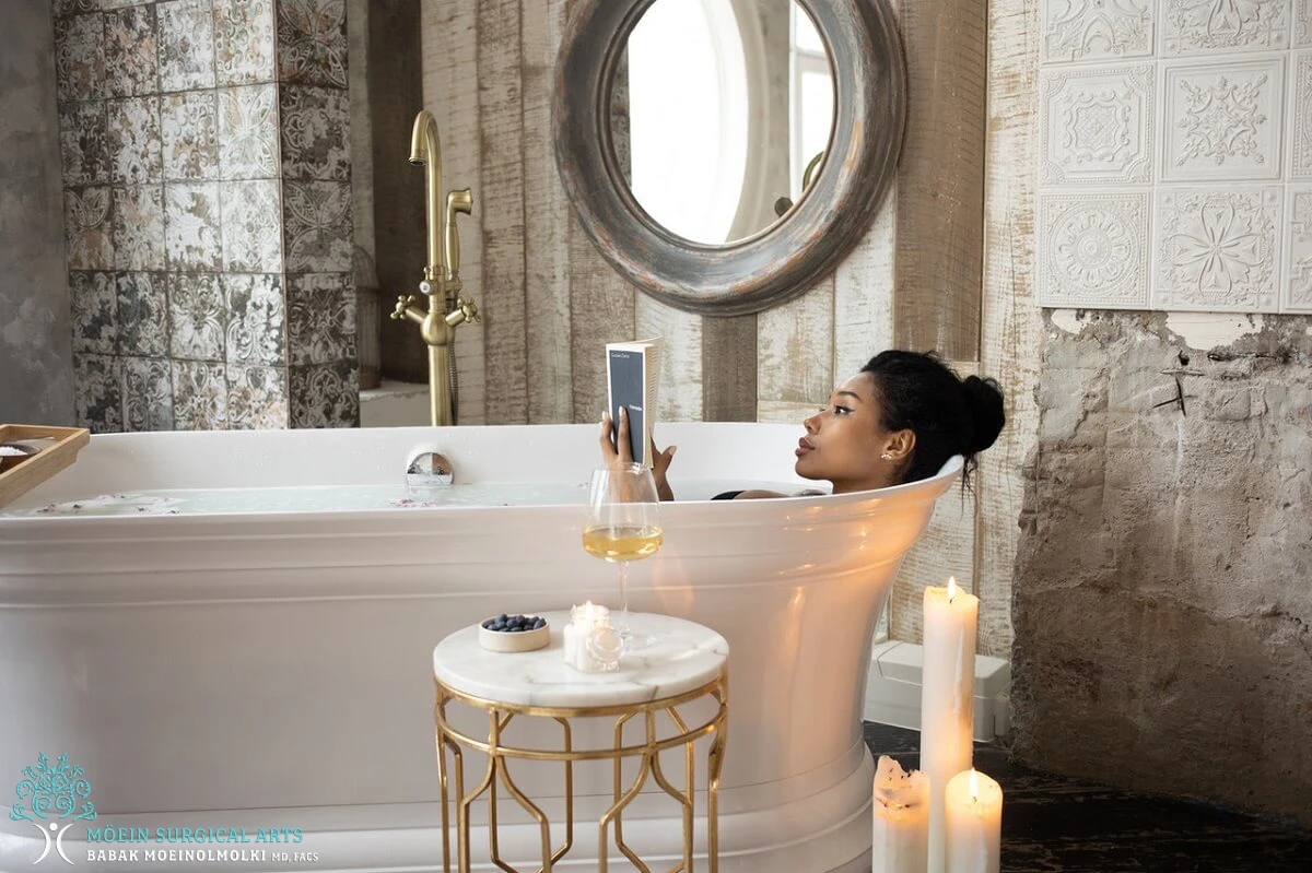 A woman taking a selfie in a bathtub with candles.