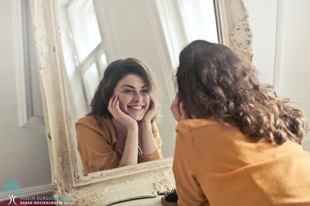 A woman looking at herself in the mirror.