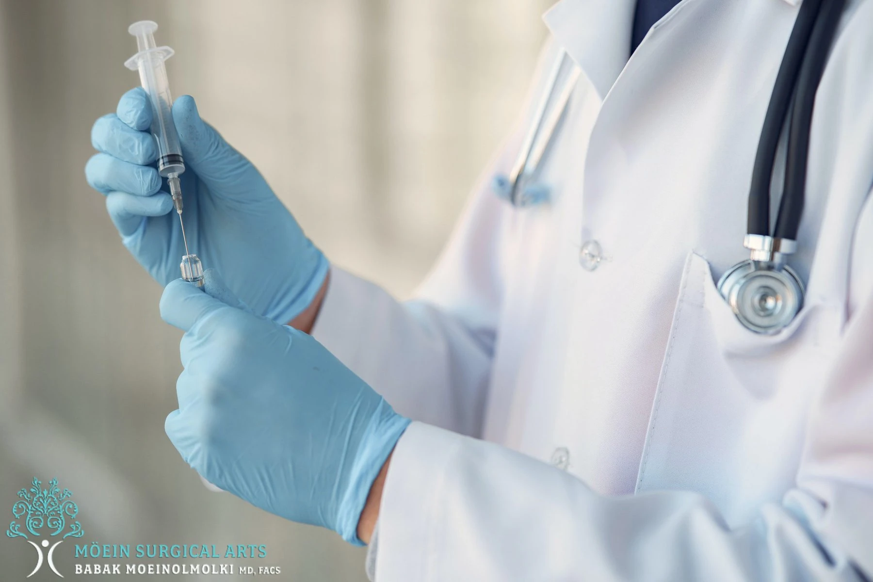 A doctor in blue gloves holding a syringe.