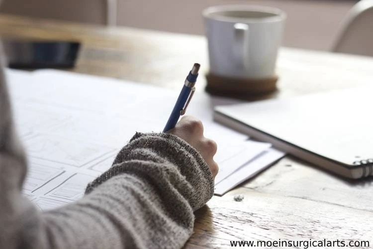 A person sitting at a table with a pen and paper.