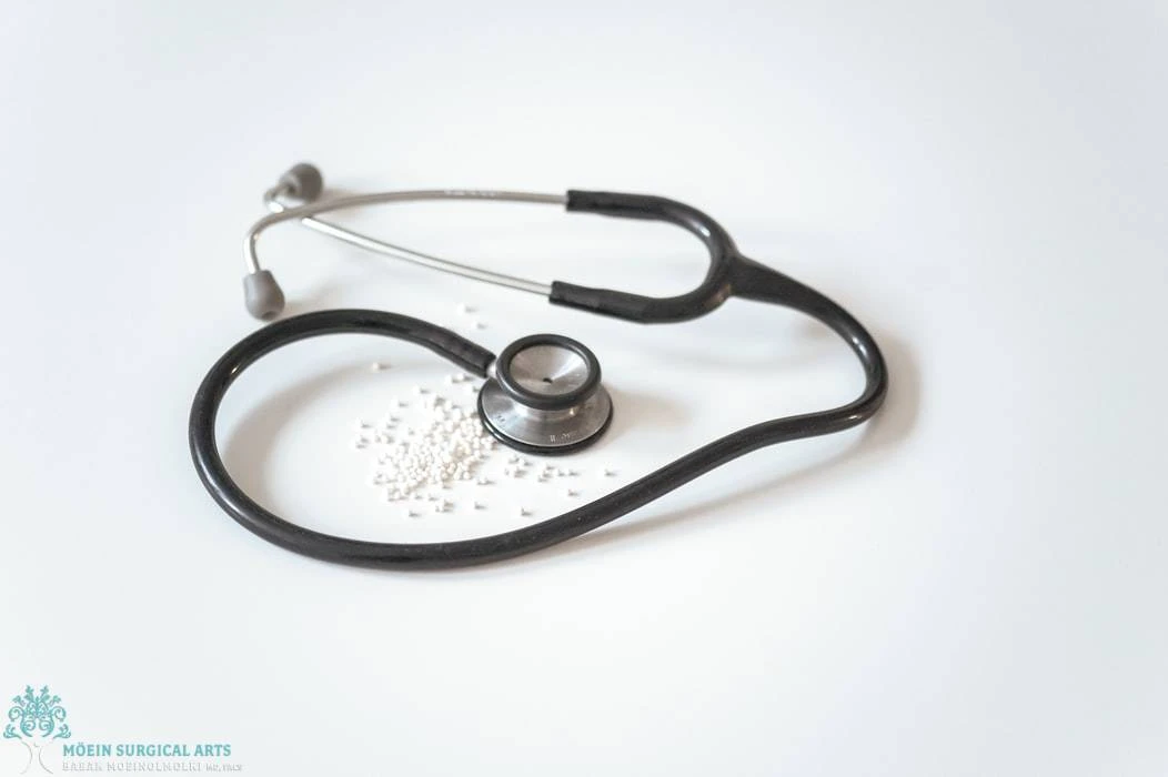 A stethoscope and pills on a white background, relevant for Gynecomastia Surgery.